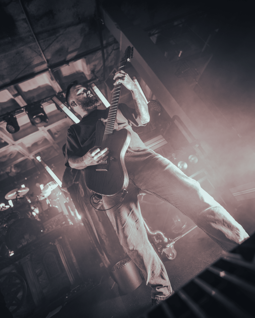 A gritty black and white photo of a metal bass player.