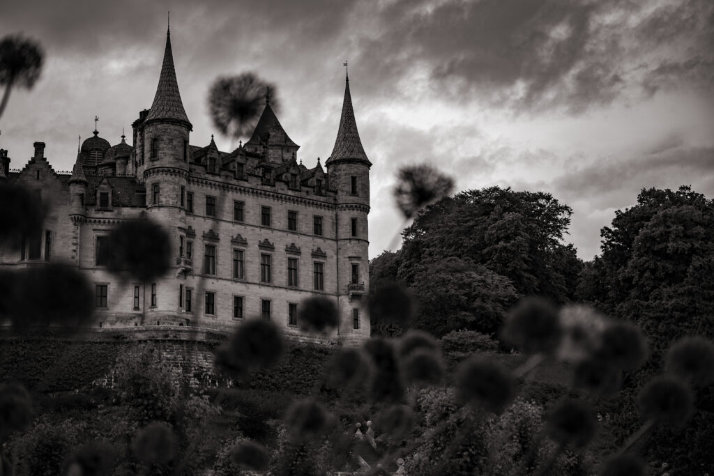 A black and white photograph of a medieval castle in the Scottish highlands.