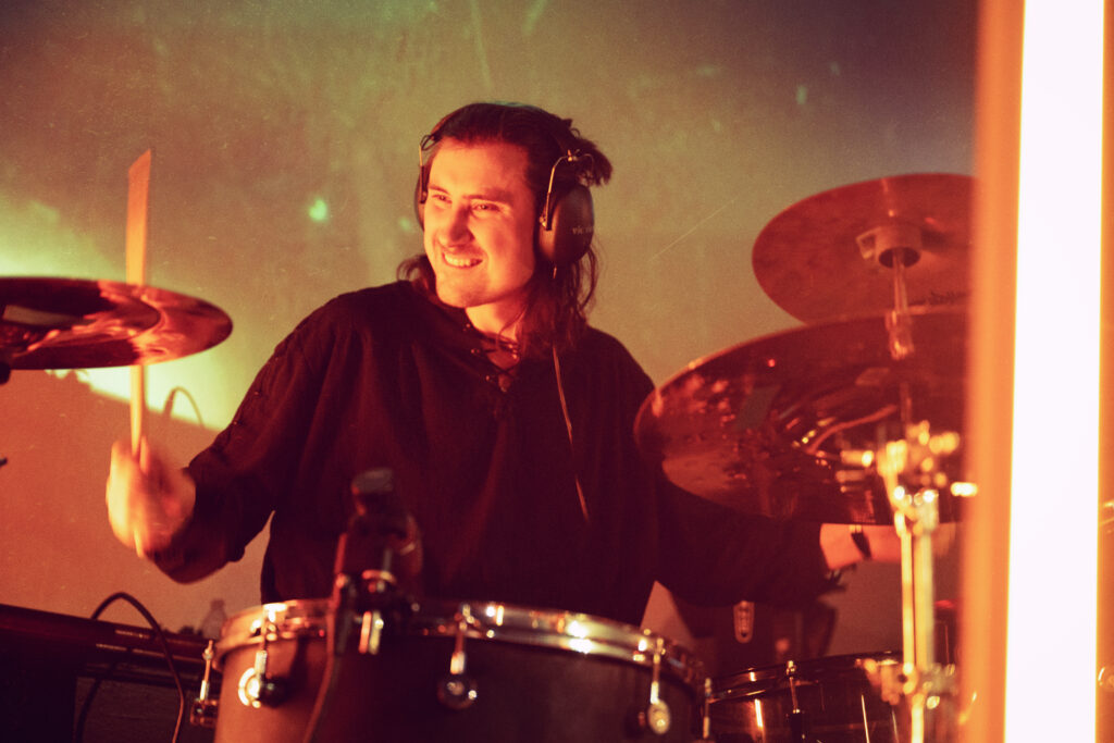 Drummer with complementary stage lights and motion blur..