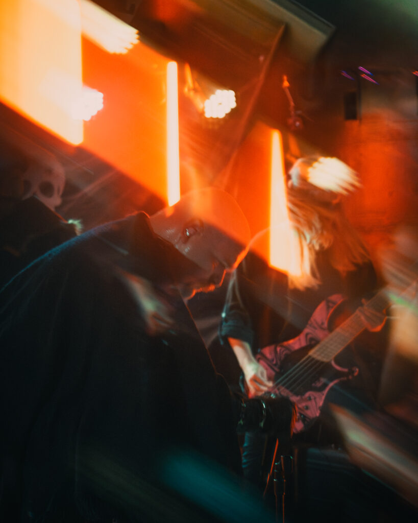 Metal concert vocalist under red lights with unique blur.
