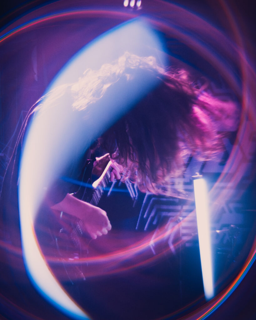 A cyberpunk inspired photo of a metal guitarist encircled by neon colors.