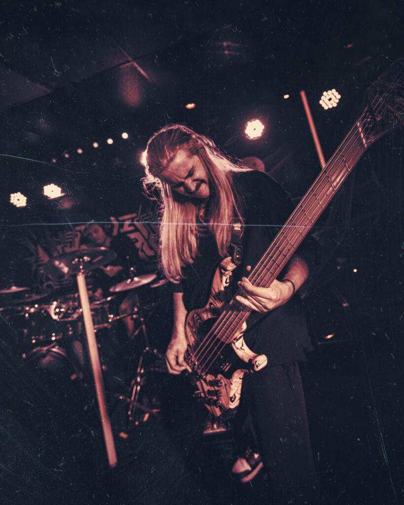 Gritty picture of a metal bass player by AE Ferguson