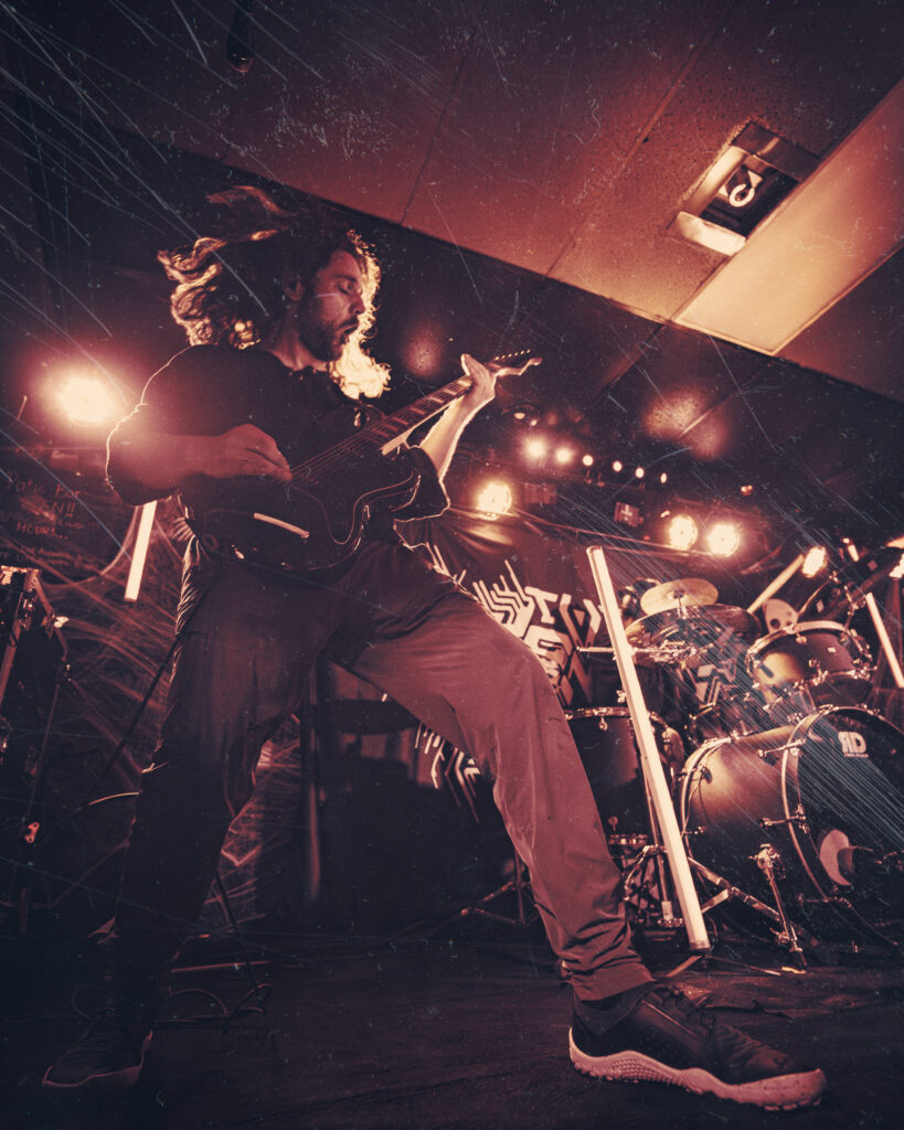 A grungy wide angle shot of an edgy metal guitarist.
