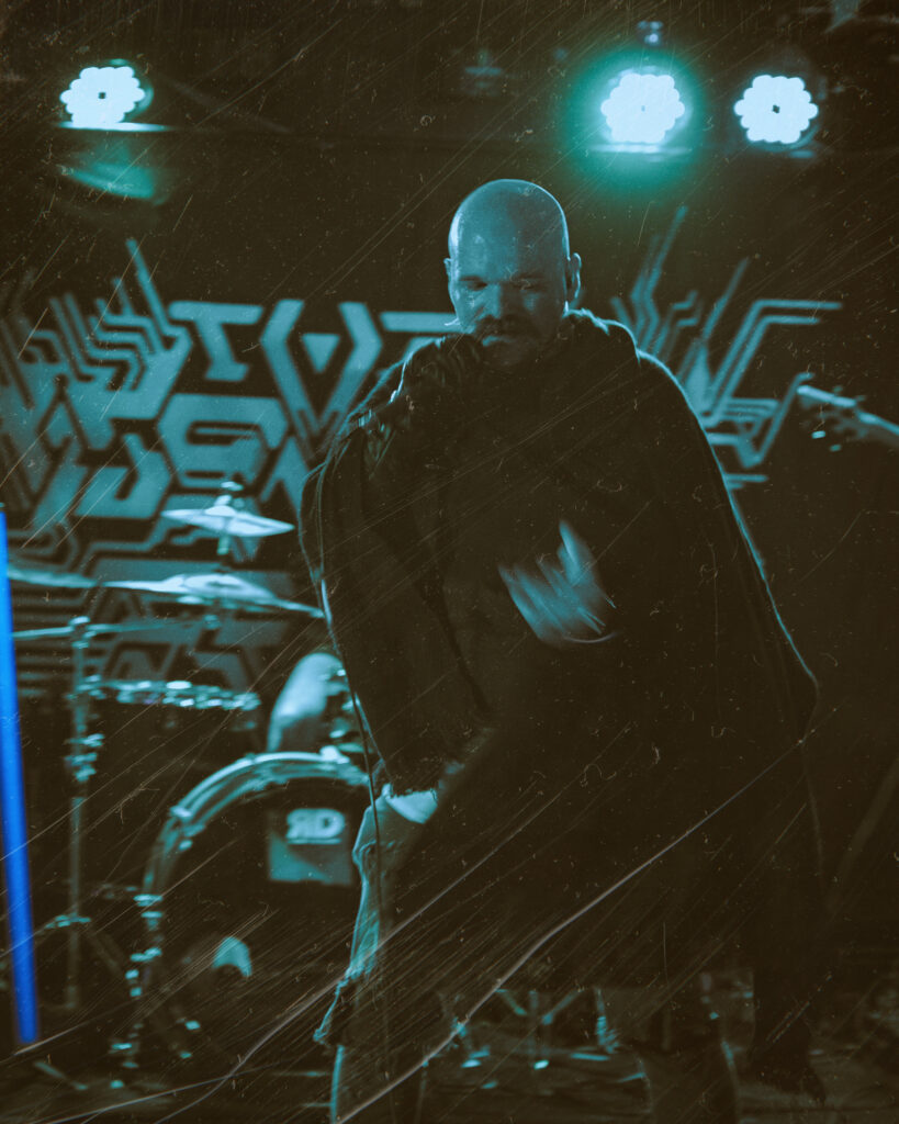 Metal vocalist screaming into a microphone with motion blur.